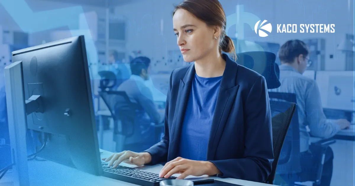 An image that represents the blog title: The Hidden Cost of an IT Provider Who Never Pushes Back. A woman is sitting at the computer, in a black blazer and blue shirt, looking concerned. You can see a busy office behind her.
